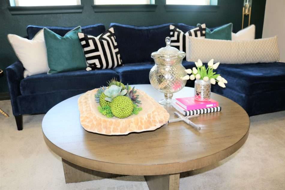 colorful family room, navy sofa, blue sofa, roman shades, black roman shades, green wall, green wall with navy sofa, tripod lamp, coffee table decor