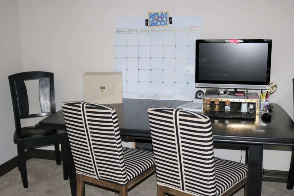 colorful family room, navy sofa, blue sofa, roman shades, black roman shades, green wall, green wall with navy sofa, tripod lamp, coffee table decor, homeschool desk